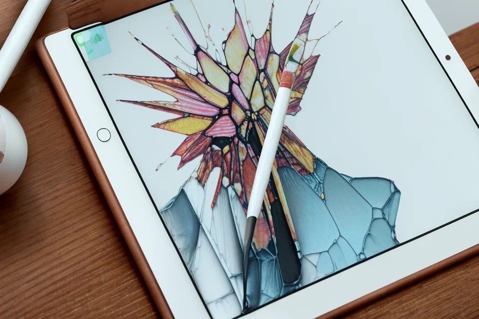 Primer plano del Apple Pencil creando formas abstractas dispersas en la pantalla del iPad